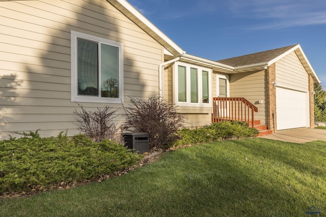 5235 Weathervane Ln, Rapid City, SD 57703 - view of side of home featuring a lawn, an attached garage, concrete driveway, and roof with shingles