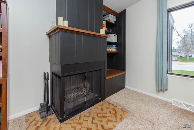 3005 Glenwood Dr, Rapid City, SD 57702 - details featuring a multi sided fireplace, baseboards, visible vents, and carpet flooring