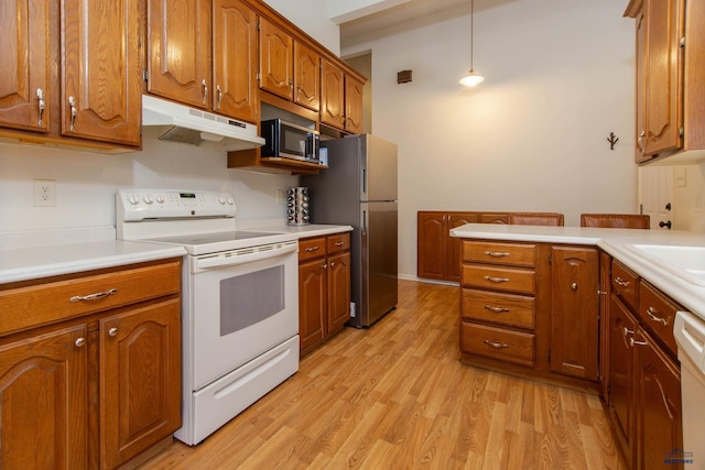 3005 Glenwood Dr, Rapid City, SD 57702 - kitchen with brown cabinetry, light wood-style flooring, appliances with stainless steel finishes, and under cabinet range hood