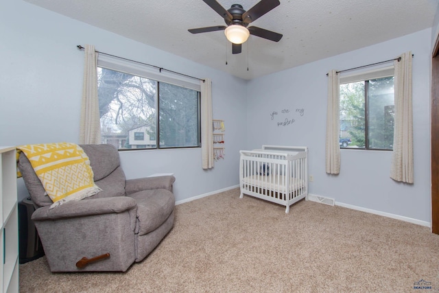 3005 Glenwood Dr, Rapid City, SD 57702 - bedroom featuring baseboards, a crib, a textured ceiling, a ceiling fan, and carpet