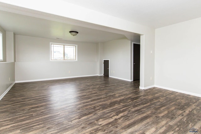 empty room with baseboards and dark wood-style floors