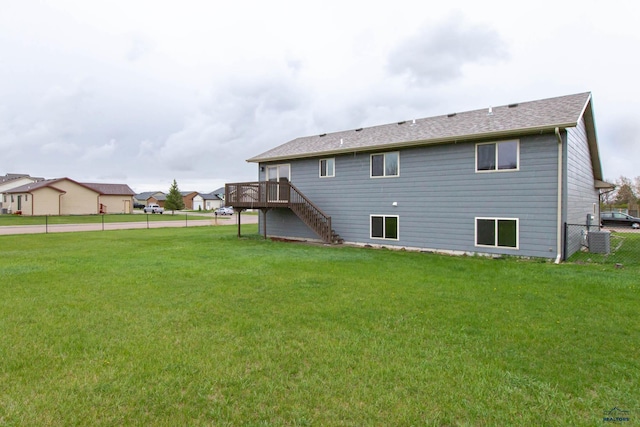 back of house featuring a lawn, a wooden deck, stairway, and fence