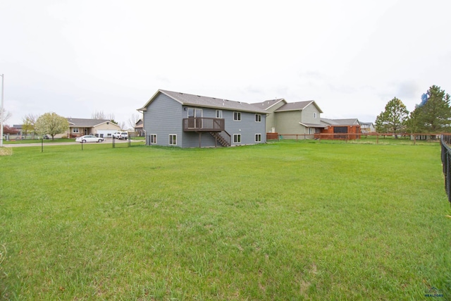 back of house with stairway, a yard, a wooden deck, and a fenced backyard