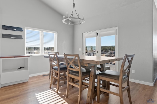 13416 Frontier Loop, Piedmont, SD 57769 - dining room with baseboards, light wood-type flooring, high vaulted ceiling, and a notable chandelier