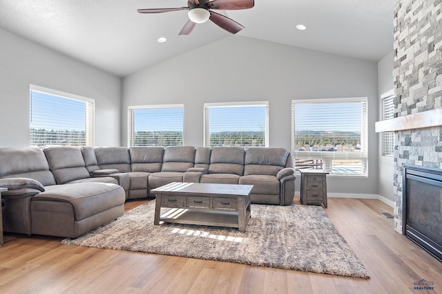 13416 Frontier Loop, Piedmont, SD 57769 - living room featuring wood finished floors, a stone fireplace, baseboards, ceiling fan, and high vaulted ceiling