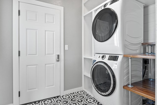 13416 Frontier Loop, Piedmont, SD 57769 - laundry area featuring stacked washing maching and dryer, baseboards, tile patterned flooring, and laundry area