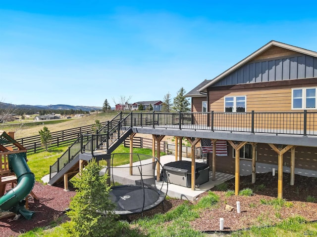 13416 Frontier Loop, Piedmont, SD 57769 - exterior space with a wooden deck, stairs, board and batten siding, a trampoline, and a hot tub