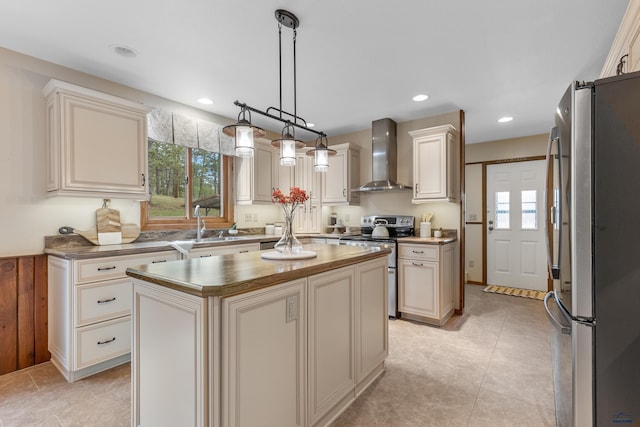kitchen featuring cream cabinets, wall chimney range hood, and stainless steel appliances