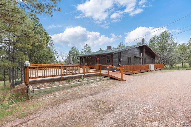 exterior space with a wooden deck and a chimney