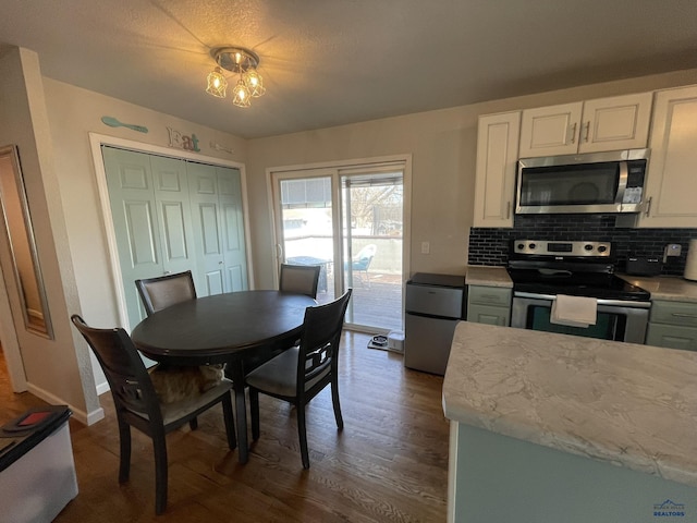dining area featuring baseboards and dark wood-style floors