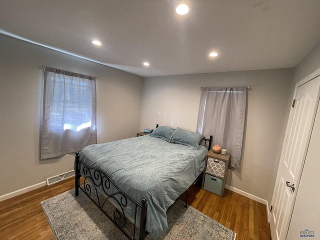 bedroom featuring baseboards, recessed lighting, wood finished floors, and visible vents