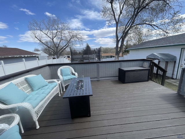 wooden deck with fence and an outdoor living space with a fire pit