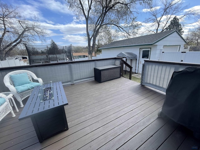 wooden deck featuring an outbuilding and an outdoor fire pit