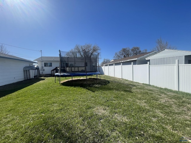 view of yard with fence and a trampoline