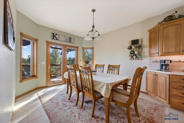 dining room featuring baseboards, a chandelier, and light tile patterned floors