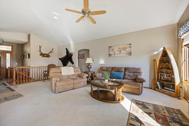 carpeted living area with ceiling fan and vaulted ceiling