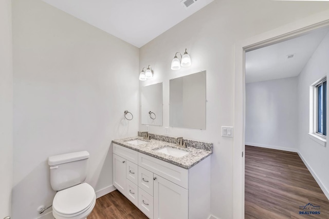 3226 W Rapid, Rapid City, SD 57702 - bathroom featuring double vanity, wood finished floors, toilet, baseboards, and a sink