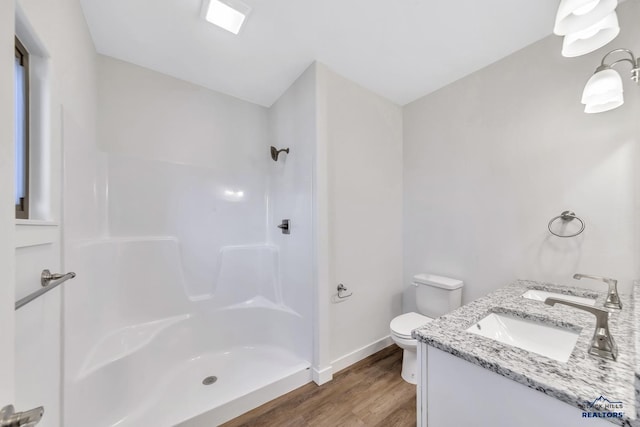 3226 W Rapid, Rapid City, SD 57702 - full bathroom with a shower, a sink, wood finished floors, and toilet