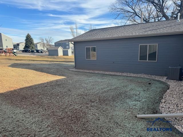 3226 W Rapid, Rapid City, SD 57702 - view of side of home with a storage unit, roof with shingles, and an outbuilding