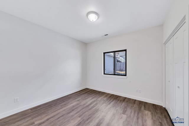 3226 W Rapid, Rapid City, SD 57702 - unfurnished bedroom with a closet, baseboards, wood finished floors, and visible vents