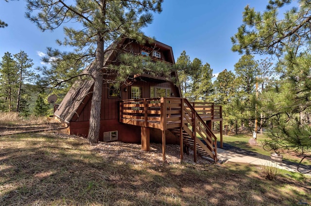 back of property featuring a wooden deck and stairs