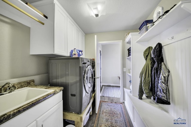 4376 Vinecliff Dr, Rapid City, SD 57701 - laundry room with a textured ceiling, washing machine and clothes dryer, cabinet space, a sink, and dark wood-style floors