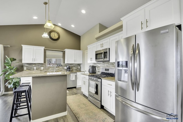 4376 Vinecliff Dr, Rapid City, SD 57701 - kitchen with backsplash, stainless steel appliances, white cabinetry, and a kitchen breakfast bar