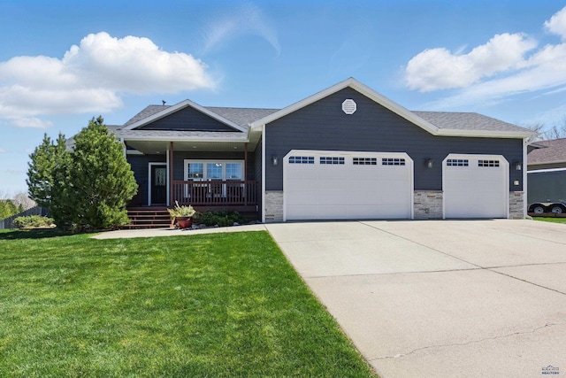 view of front of property featuring covered porch, an attached garage, concrete driveway, and a front lawn