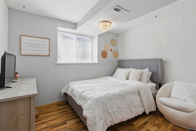 bedroom featuring visible vents and wood finished floors