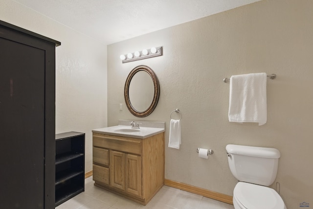 bathroom featuring vanity, baseboards, toilet, and tile patterned flooring