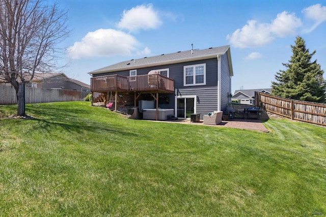 rear view of property featuring a fenced backyard, a patio, a hot tub, and a deck