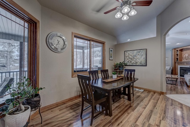 6642 Carnoustie Ct, Rapid City, SD 57702 - dining space with arched walkways, a ceiling fan, baseboards, and light wood-style floors