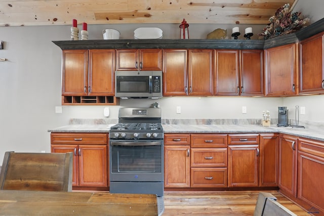 21298 Ridgewood Trl, Lead, SD 57754 - kitchen featuring light wood finished floors, light countertops, stainless steel appliances, and brown cabinetry
