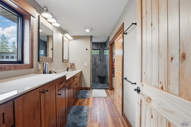 21298 Ridgewood Trl, Lead, SD 57754 - full bathroom featuring a stall shower, baseboards, vanity, and wood finished floors