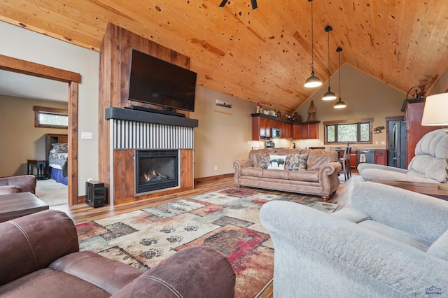 21298 Ridgewood Trl, Lead, SD 57754 - living area with lofted ceiling, a warm lit fireplace, wood finished floors, wood ceiling, and baseboards