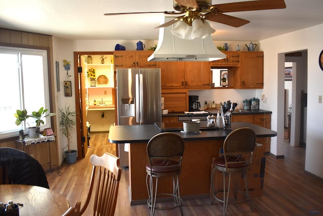 2911 Orchard Ln, Rapid City, SD 57701 - kitchen with wood finished floors, dark countertops, brown cabinetry, stainless steel fridge with ice dispenser, and ceiling fan