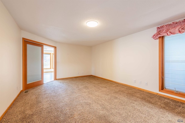 unfurnished room featuring carpet flooring, baseboards, and visible vents