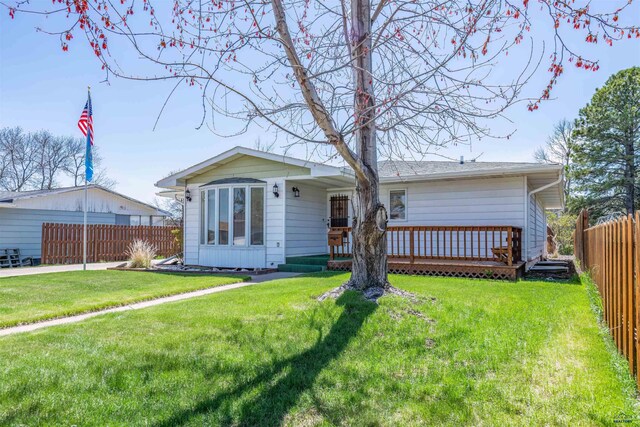 single story home featuring a fenced backyard, a deck, and a front lawn