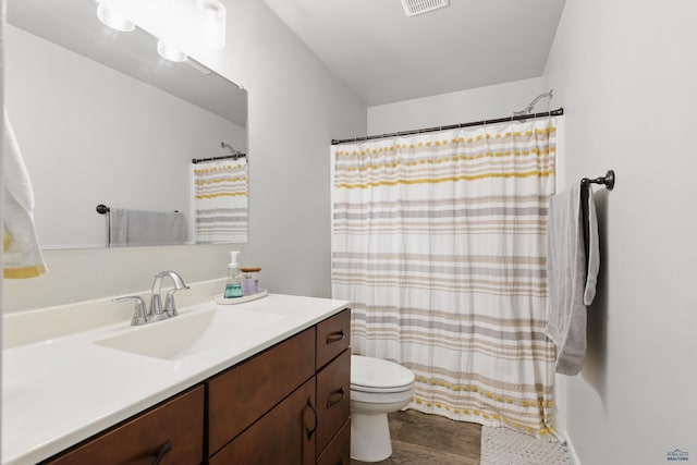 bathroom featuring toilet, vanity, wood finished floors, and curtained shower