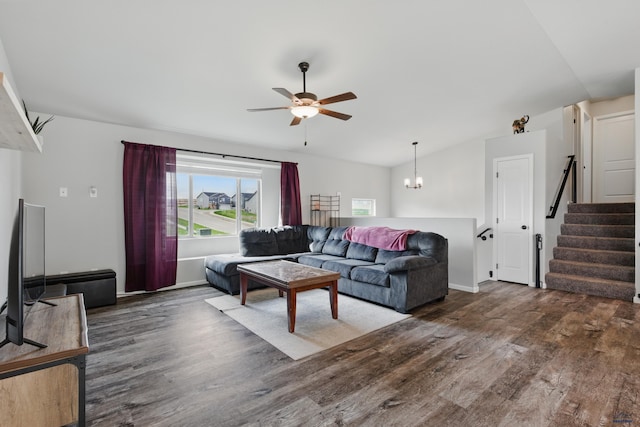 living area featuring wood finished floors, ceiling fan, vaulted ceiling, stairs, and a chandelier