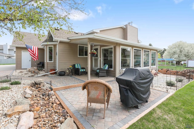 7315 Raven Ct, Rapid City, SD 57702 - rear view of house with fence, a sunroom, a patio area, and a shingled roof