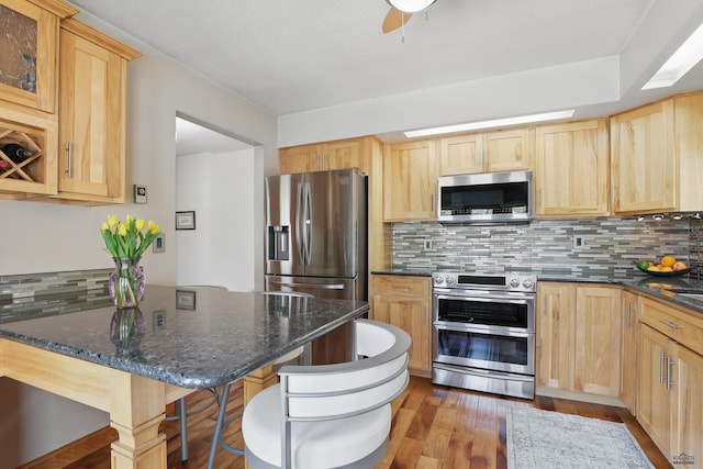 7315 Raven Ct, Rapid City, SD 57702 - kitchen with appliances with stainless steel finishes, light brown cabinets, decorative backsplash, and wood finished floors