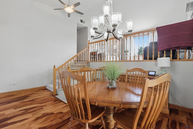 7315 Raven Ct, Rapid City, SD 57702 - dining room with wood finished floors, stairway, a chandelier, a ceiling fan, and lofted ceiling