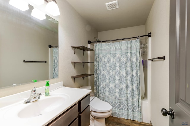 bathroom with toilet, wood finished floors, vanity, and shower / bath combo with shower curtain
