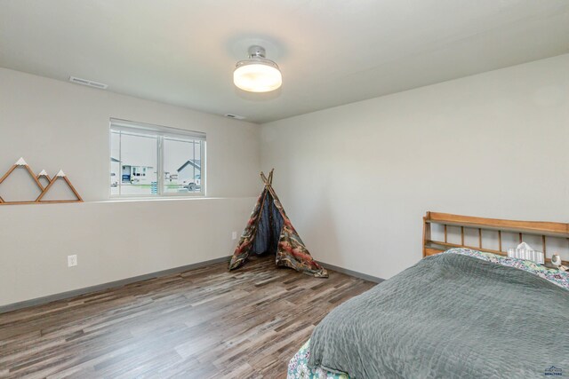 bedroom featuring wood finished floors and baseboards