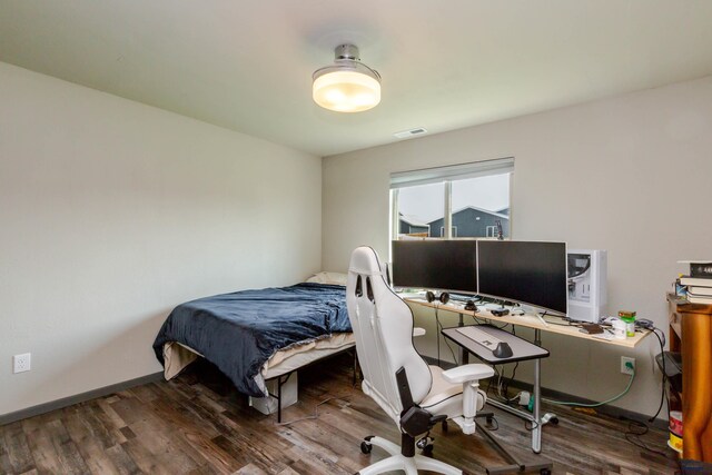 bedroom featuring wood finished floors and a desk