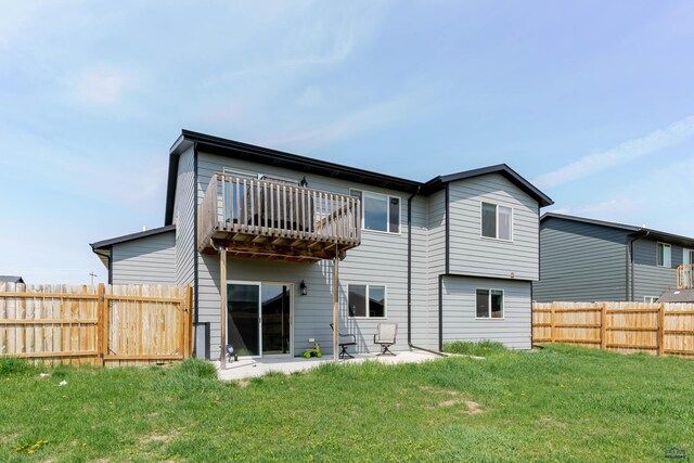 rear view of property featuring a balcony and a patio area