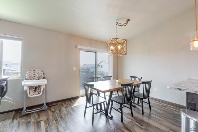 dining room with a chandelier, dark wood-type flooring, and baseboards