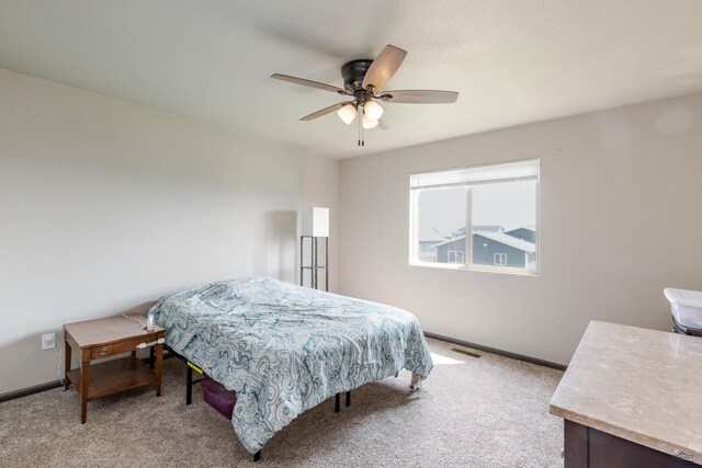 bedroom featuring light carpet, baseboards, and a ceiling fan