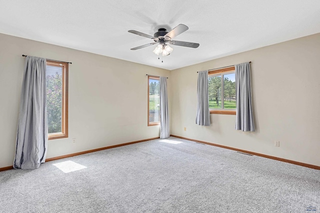 carpeted empty room with baseboards and ceiling fan